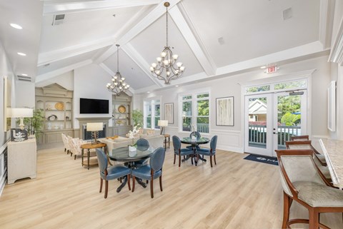 a dining room with a table and chairs and a living room with windows